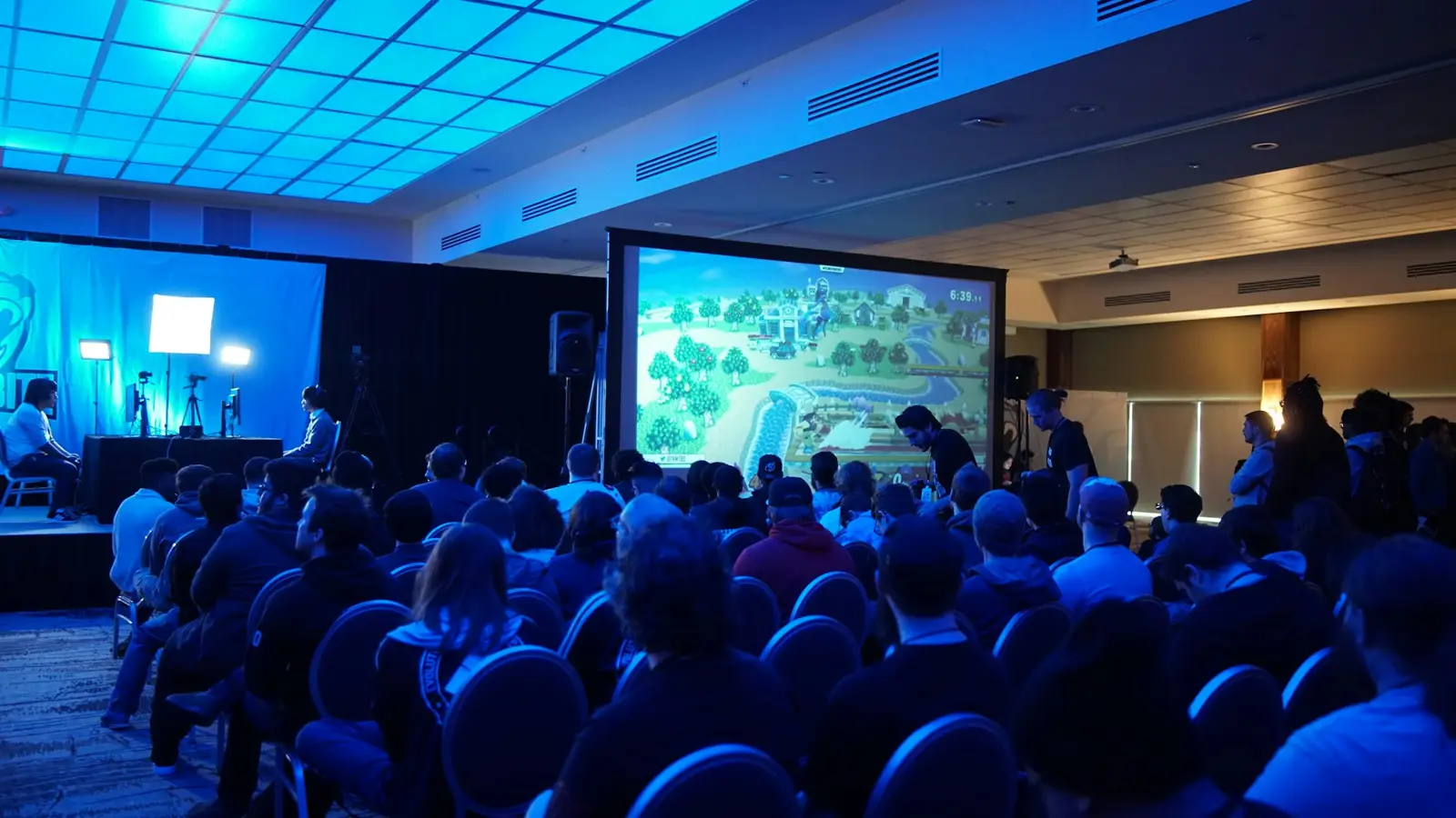 A hotel ballroom set for a conference with a large projection screen
