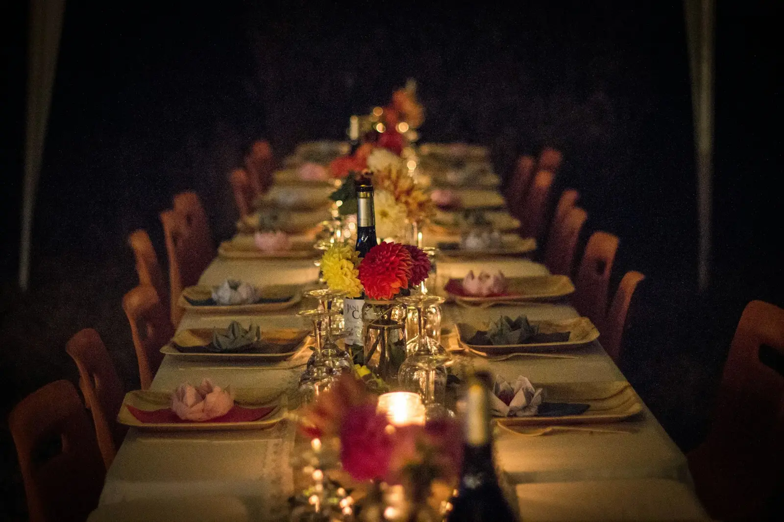 A long dinner table set with candles and flowers